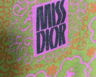 Closeup of the vintage Christian Dior silk scarf, pale green with pink and orange floral design and Miss Dior logo
