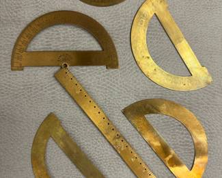 Antique brass drafting tools, including protractors and a ruler