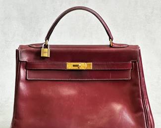 Ooh la la – a 1953 vintage Hermès Kelly bag, authenticated by Entrupy, in bordeaux or Rouge H box leather with gold plated hardware. Originally designed in the 1930s and known as the "Sac à dépêches bag" the style was renamed "Kelly" after the popularity of the design skyrocketed when actress Grace Kelly, newly married Princess of Monaco, was photographed carrying the iconic Hermès handbag.