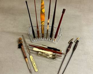 A variety of vintage calligraphy dip pens and writing instruments, and an antique celluloid letter opener advertising "The German Insurance Company of Freeport Illinois" from the early 1900s