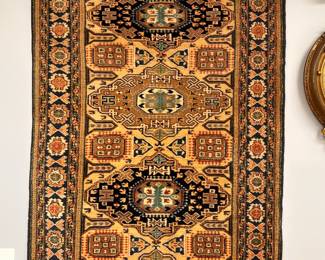 A vintage Persian area or prayer rug with intricate geometric patterns and a medallion design in gold, brown and black color palette; approximately 4' x 6'