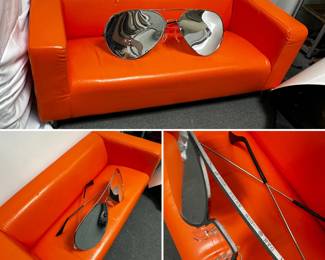 A giant pair of aviator sunglasses with mirrored lenses and a silver metal frame stamped "1984 Think Big NYC 10012"