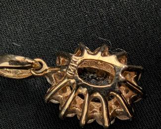 Closeup of the 14k yellow gold sapphire and diamond pendant