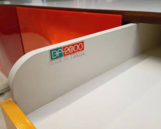 Closeup of inside the Raymond Loewy DF2000 two-sided room divider cabinet, by Raymond Loewy for Doubinsky Freres, 1968; a marvelous two-sided, eight door buffet or room divider from the ‘DF2000’ collection, with eight doors situated on two sides, the fronts moulded from vivid red Metacrylene set in a frame of off-white plastic supported by moulded aluminum lacquered white.