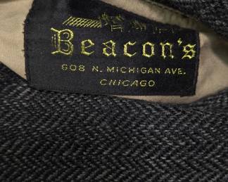 Closeup of the vintage herringbone tweed overcoat, often styled as a balmacaan coat with raglan sleeves