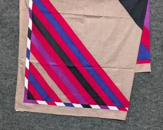 A cotton scarf with tan background and diagonal stripes in red, pink, black, purple, and blue; 100% cotton, made in Italy