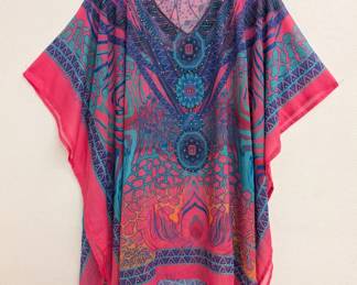 A colorful Digital Desert caftan in pinks and blues, tiny gold color beads outline the V neckline, sleeves, and hem