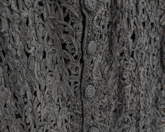 Closeup of the swingy little vintage black sleeveless dress of woven/crocheted ribbon work or ribbon soutache 