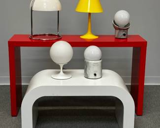 Mid-century Modern lamps and tables including a Laurel lamp with white globe shade and tulip base designed by Bill Barr, a Neal Small mushroom "Miri" lamp with white dome shade and chrome-plated round tube metal frame, 1970s. A "waterfall" style white table 36"W x 18"H x 18"D, and red rectangular table with inline casters, 49-1/4"W x 28-3/4"H x 14-1/4"D. Iconic MCM furnishings! 