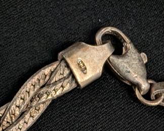 Closeup of two sterling silver braided herringbone chain necklaces