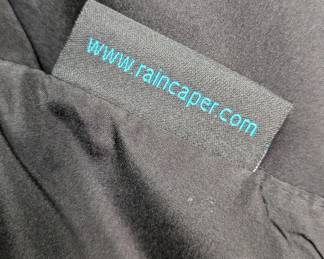 Closeup of the Raincaper women's black and tan hooded rain poncho