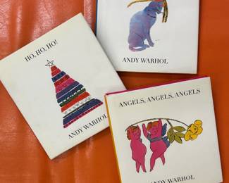 Three collectible hardcover books with illustrations by Andy Warhol: Ho, Ho, Ho!; Cats, Cats, Cats; and Angels, Angels, Angels