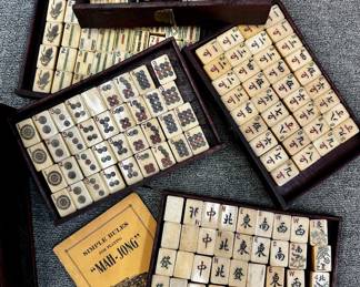 Another view of the antique Chinese Mahjong set circa 1923 with tiles, betting sticks, and dice in a dark wood cabinet or drawered chest which includes a sliding front panel and brass handles.  
