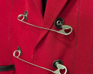 Closeup of 1980s vintage Jean Paul Gaultier Pour Gibo red wool suit featuring iconic maxi safety pin closures and black leather details