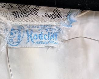 Closeup of the 1940s Radcliff ivory color dressing robe with lace detailing at neck, waist and cuffs; rayon