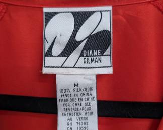 Closeup of Vintage 1980s Diane Gilman coral red silk jacket with wide lapels and peplum waist, size M