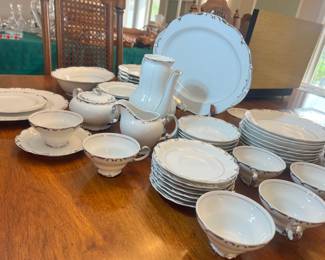 Large set of elegant white porcelain dinnerware with polished silver-rim detailing
