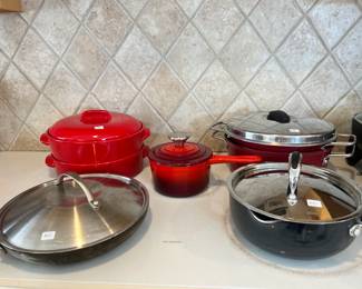 Le Creuset enameled cast iron saucepan and an array of stainless cookware