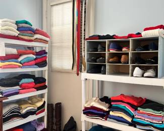 Massive collection of folded sweaters, pashminas, leather boots, and a variety of colorful belts
