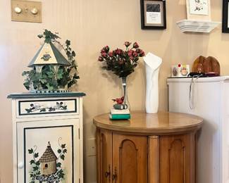 Hand-painted birdhouse-themed accent cabinet alongside a traditional wood drum table