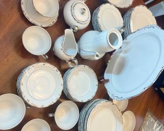 Large set of elegant white porcelain dinnerware with polished silver-rim detailing
