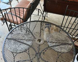 wrought iron bistro table with two chairs and cushions