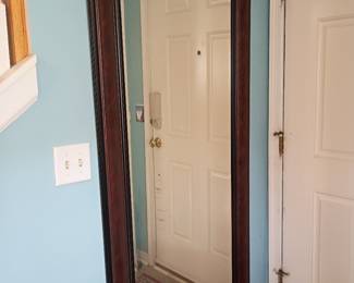 Large wood-framed full-length wall mirror