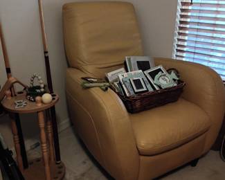 Tan leather club chair with fishing gear
