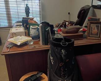Cleveland Golf bag and dark wood home office desk