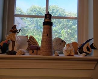 Ceramic lighthouse, hula figurine, fish, and shells