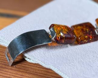 This lot features a stunning sterling silver & baltic amber bracelet that measures, 7” with a total approx. weight of 61.80 grams.