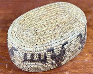 This lot features a stunning Native American basket, likely from the 1920s-1930s, made from heavy woven grass. This basket measures 3.75” H x 9.25” W x 6.5” D.