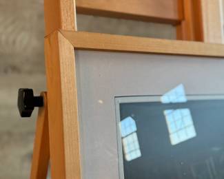 Framed portrait of a woman wearing a green headdress, depicted in a dark tonal palette. The artwork is presented in a wooden frame with white matting. The backing paper is torn, showing wear. Measures in frame, 28” H x 23” W.