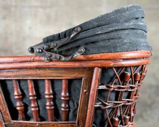 This lot features a beautiful antique Victorian-style doll carriage made from wicker, wood, and metal. This piece measures, 17.5” H x 19” W x 7” D.