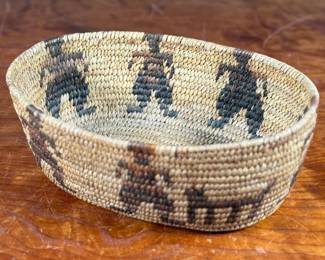 This lot features a stunning Native American basket, likely from the 1920s-1930s, made from heavy woven grass. This basket measures 3.75” H x 9.25” W x 6.5” D.