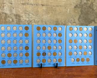 Three coin collection folders produced by Whitman Publishing Company, featuring Lincoln Cents (Collection 1909-1940, Number One; and Collection Starting 1941, Number Two) and Jefferson Nickels (Collection 1938 to 1961, Number One). The folders display various coins, including partially filled slots with different years. Condition shows general wear on the folders. Coin details and completeness vary.