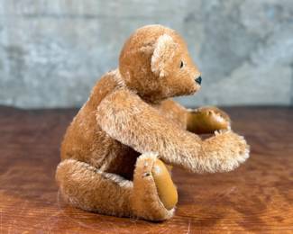 Steiff original teddy bear featuring brown mohair fur and a classic black stitched nose. Retains the trademark Steiff tag in the ear and button. In good condition with visible iconic craftsmanship.