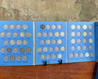 Three coin collection folders produced by Whitman Publishing Company, featuring Lincoln Cents (Collection 1909-1940, Number One; and Collection Starting 1941, Number Two) and Jefferson Nickels (Collection 1938 to 1961, Number One). The folders display various coins, including partially filled slots with different years. Condition shows general wear on the folders. Coin details and completeness vary.