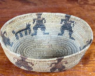This lot features a stunning Native American basket, likely from the 1920s-1930s, made from heavy woven grass. This basket measures 3.75” H x 9.25” W x 6.5” D.