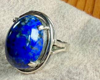 This lot features a vintage sterling silver ring with a large lapis center stone. This ring comes in a size 6 with a total approx. weight of 7.29 grams.