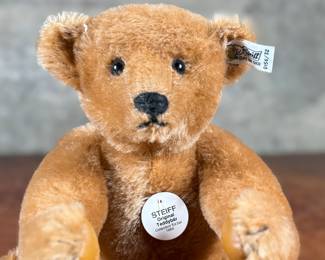 Steiff original teddy bear featuring brown mohair fur and a classic black stitched nose. Retains the trademark Steiff tag in the ear and button. In good condition with visible iconic craftsmanship.