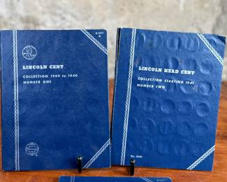 Three coin collection folders produced by Whitman Publishing Company, featuring Lincoln Cents (Collection 1909-1940, Number One; and Collection Starting 1941, Number Two) and Jefferson Nickels (Collection 1938 to 1961, Number One). The folders display various coins, including partially filled slots with different years. Condition shows general wear on the folders. Coin details and completeness vary.