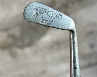 A vintage Frank Bryan Special Mashie golf club featuring a steel head and a wooden shaft. The head is marked with branding and includes the inscription ‘Special Mashie.’ The club has a textured steel clubface and a leather-wrapped grip, showing signs of wear consistent with use and age.