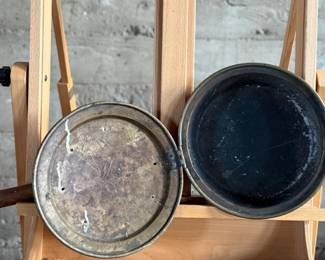 Brass bed warmer with floral etching and decorative perforations on the lid. The piece features a wooden turned handle with a rich patina and a hinged lid. The brass showcases signs of use with wear and age-related patina. The perforations were traditionally used for dispersing heat by placing warm materials inside the bed warmer. Suitable for collectors or historical display.