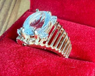 This lot features a 14k gold ring with a quartz center stone surrounded by four genuine diamonds. This ring comes in a size 6.5 with a total approx. weight of 7.71 grams.