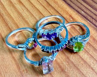 This lot features a collection of five (5) sterling silver rings with various stones. One of the rings is also marked 10k. Total approx. weight of 12.30 grams with ring sizes including 6, 6.5, 7, 7.5, & 8.