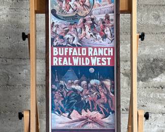 Framed posters advertising the Buffalo Ranch Real Wild West show. Printed by Riverside Print Co., Chicago, these posters feature vibrant depictions of cowboys, Native Americans, and historical scenes. The frames show some age-related wear, and the paper backing is partially torn, exposing an art gallery label from Hulmeville, Pennsylvania. One of them is protected by glass and the other is not. Each one measures in frame, 37” H x 14.5” W.