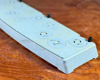 Vintage 1978 Star Wars action figure display stand by GMFGI. Marked ‘321E 001’ with a copyright of ‘G.M.F.G.I. – 1978’. Features slots marked with character names including Stormtrooper, Darth Vader, Luke Skywalker, and Princess Leia. Made of gray plastic with attached gear mechanisms on the back and visible character labels on the front. Some wear consistent with age.