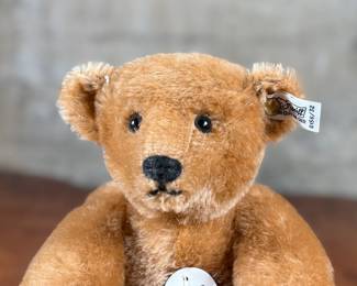 Steiff original teddy bear featuring brown mohair fur and a classic black stitched nose. Retains the trademark Steiff tag in the ear and button. In good condition with visible iconic craftsmanship.