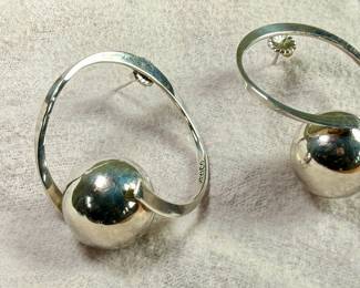 Sterling silver earrings designed in a modernist style, featuring circular hoops with a spherical accent. Marked ‘Mexico 925’, indicating its sterling silver composition. These earrings are designed with posts and butterfly back closures for secure wearing. Total approx. weight of 17.06 grams.